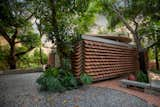 Recycled Roof Shingles Become a Textured Fence For a Curved Home in India - Photo 3 of 15 - 