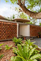 Recycled Roof Shingles Become a Textured Fence For a Curved Home in India - Photo 1 of 15 - 