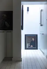 A view looking into into the kitchen, which features an original light well and two art pieces by unknown painters.