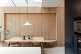 The oak dining nook sits under a frameless glass skylight. 