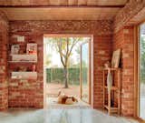 The material palette is simple by design: red brick, polished concrete, and wood.