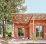 Glass doors connect each bedroom to its own small patio space, covered by thatched pergolas. 