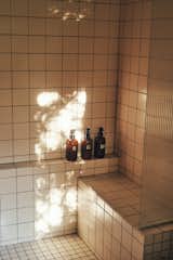 Ribbed glass accents, both in the shower and throughout the space, add depth without creating visual noise in the apartment's small footprint. 