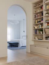 The primary bedroom features the floor-to-ceiling drapes that are a staple throughout the new renovation, highlighting the home's tall ceilings.