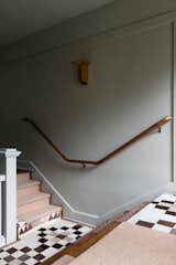 The hallway features another custom rug using the owners' antique pieces.
