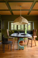 A custom walnut table by Studio AHEAD anchor the dining room. The bases are repurposed Jeffie Brewer sculptures that the clients had previously purchased.