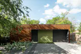 This highly efficient ADU-as-primary residence makes the most of its compact site within a dense, active neighborhood. While it has no perimeter windows, the interior is anything but dark and cramped thanks to two internal landscaped courtyards that flood the 1,100-square-foot home with light and glimpses of nature.