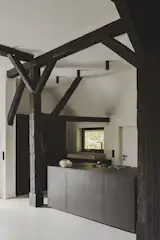 The kitchen, designed by Next125, includes a ceramic countertop by Lechner, a Miele oven, and a walk-in pantry. 