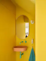 In the powder room, aqua fixtures by Rubinet complement a peach concrete sink by Mudd.