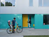 A turquoise recessed door leads to the town house, while a yellow recessed door is a sunny signifier of the family’s main entrance.