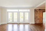 In the living room, the original windows have been replaced with French doors that open to a stone terrace.&nbsp;