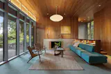 The living room and the adjacent dining room function as the architectural and programmatic heart of the home, conceived as spaces for gathering and socializing amidst views of the landscape.