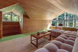 An upper-level lounge area offers views of the forest canopy. 