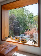 Warm larch wood frames the doors and windows, some of which project out toward the garden. 