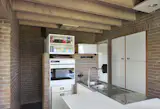 The ground floor features a kitchen, a living area, and a dining room and an entrance to the first of four duplexes, which function like private wings.