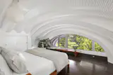 White galvanized steel arches span the ceiling of the primary bedroom.&nbsp;&nbsp;