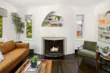 In the living room, a woodburning fireplace is complemented by an elliptical mantel.&nbsp;&nbsp;