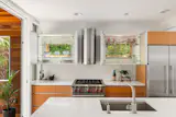 The kitchen has a Wolf range, Franke hood, and daylit upper cabinets fronted with frosted glass.&nbsp;&nbsp;