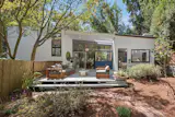 Both the front and back facades are defined by a series of large windows, enhancing the home's connection to the surrounding landscape from nearly every room.
