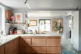 The extension includes a new Craigie Woodworks kitchen with natural oak cabinets, granite counters, and brass detailing.&nbsp;