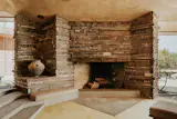 A stone fireplace anchors the living area, which features mitered glass corners.&nbsp;