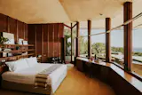 The primary bedroom opens to the outdoors via two floor-to-ceiling glass doors.&nbsp;