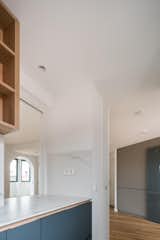 Kitchen details: Stone countertop, wooden up storage and a window connecting the hole area.
