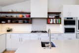 New kitchen remodel with Caesarstone London Fog 2CM countertops, custom drywall hood, custom natural walnut open shelves.