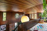 A closer look at the Frank Lloyd Wright glass windows and the beautiful wood detail of the paneled walls, ceiling and staircase.