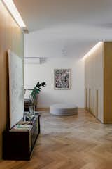 Hallway and Medium Hardwood Floor The challege was to  maintain, restore and reapply all of the existing Japanese ash wood paneling that divides the previous floorplan. Work was carried out exhaustively together with a Carpenter/craftsman  Photo 19 of 22 in Globa Apartment by Ariel Glot