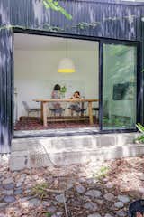 Shed & Studio and Family Room Room Type The multipurpose space in the back works as an indoor barbecue space, office or atelier, it used to be ragged shed that now is lagged in black sheet metal in order to give it a contemporary look and reduce its exterior maintenance  Photo 6 of 22 in Globa Apartment by Ariel Glot