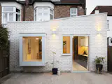 The new extension is clad in white bricks which help to bounce light around the new interiors, emphasise the freshness and newness, and create a clear, distinct separation from the existing part of the late Victorian semi-detached London home.