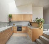 The kitchen is set lower than the living area, helping to create distinct zones while maintaining a sense of openness.