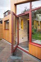 The red aluminium windows and doors from Grove Windows add colour and interest.