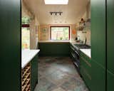 Slate tiles against forest green cabinetry looks modern and fresh.&nbsp;