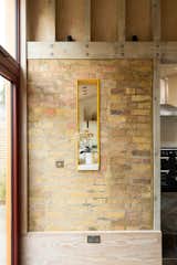 To create connectivity between zones on the ground floor, internal slot windows have been placed between the kitchen and the dining and living areas. For structural stability, steel frames were added and coated in yellow to match the yellow painted kitchen walls. 
