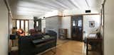 Living Room, Console Tables, Table Lighting, Sofa, Bookcase, Wall Lighting, Light Hardwood Floor, and Wood Burning Fireplace The swinging doors leading from the living room to the dining room were a fortuitous discovery in the garage rafters.   Photo 5 of 13 in The Meier House by Michael Schreiber