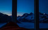 The moon rises behind East Peak as the dawn begins above the clouds.