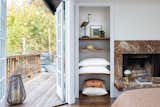 Primary bedroom with built ins and a fireplace constructed from ancient Italian marble.