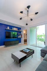 Living Room, Coffee Tables, Ceiling Lighting, Porcelain Tile Floor, Console Tables, Pendant Lighting, Sofa, Recessed Lighting, and Shelves Living Room  Photo 5 of 16 in Silver Bluff Townhouse - Miami by PRZ Design + Build