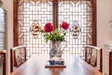 Chinoiserie framed windows adorn the dining space: a unique and exotic look with amazing intricate details. Peonies, blue & white objects, beautiful carved details of the dining chairs. 