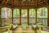 Screened in porch surrounded by woods and borders a brook
