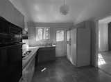 Before: Old appliances and an oversized fridge surround a small kitchen. There was limited light and view from small windows facing the rear garden and the enclosed kitchen design blocked view from the adjacent living room space.