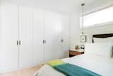 Bedroom, Bed, Storage, Wardrobe, Light Hardwood Floor, and Pendant Lighting Primary Bedroom Closets  Photo 18 of 24 in Before and After: A Faded Mid-Century Becomes Luminous by HxH Architects PLLC