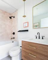 Bath Room, Porcelain Tile Floor, Undermount Sink, Concrete Counter, Pendant Lighting, Ceramic Tile Wall, and One Piece Toilet Guest bath with pink hex tile!  Photo 19 of 24 in Before and After: A Faded Mid-Century Becomes Luminous by HxH Architects PLLC