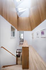 Staircase, Wood Tread, and Wood Railing The main stair was relocated to the center of the house, allowing for both a central lightwell AND another bedroom within the same house footprint.  Photo 5 of 40 in A Crisp Renovation is a SNAP for this Stale Gingerbread House by HxH Architects PLLC
