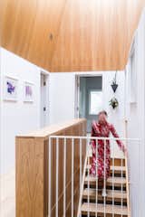 Staircase, Wood Tread, and Wood Railing A bookshelf flanks the stairs at the central stair hall  Photo 8 of 40 in A Crisp Renovation is a SNAP for this Stale Gingerbread House by HxH Architects PLLC