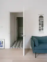 The toilet, now isolated, is tucked away beyond the entrance hallway.