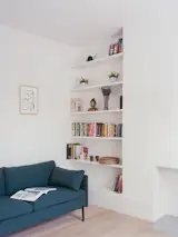 Built-in shelves replace the old bedroom wardrobes to enhance the new living room.