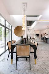 Cane back chairs bring the warmth to dining area. Martha Sturdy brass sculpture and Bocci 21 Series lighting.
